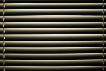 Closed blinds on the window on a sunny day.