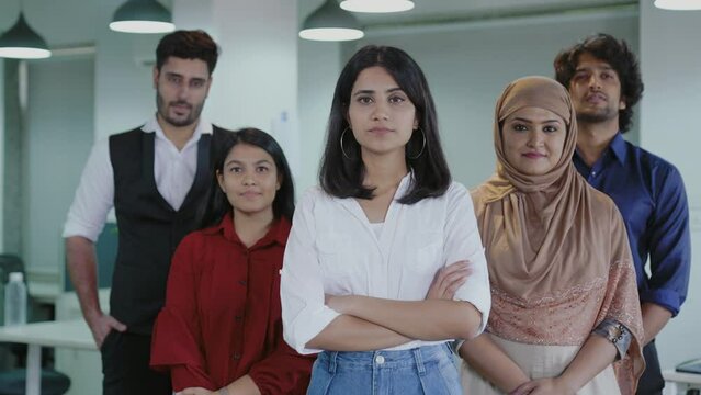 Happy young Indian diverse business people office workers team standing in row looking at camera. Multi ethnic professional employees executives group posing together for corporate portrait,leadership