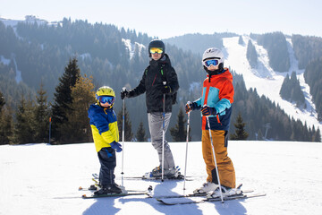 Happy family, skiing in Italy on a sunny day, kids and adults skiing together