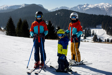 Happy family, skiing in Italy on a sunny day, kids and adults skiing together