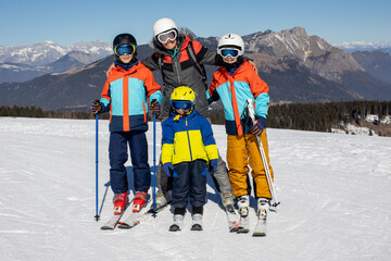 Happy family, skiing in Italy on a sunny day, kids and adults skiing together