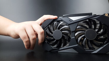 the video card is held by a teenager's hand on a black matte background. there are places for text....
