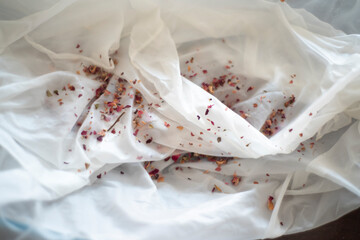 slow fashion concept - hand dying with natural colors - flowers and petals on a silk texture