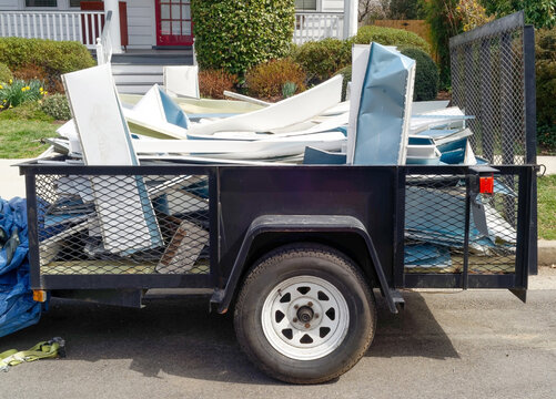 Utility trailer filled with scrap aluminum siding.