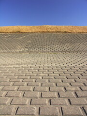 早春の枯れ草のある江戸川護岸と青空風景