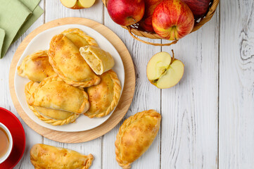 Pasties stuffed with apples. Pirozhki - russian baked puff pastry with apple fillings. Homemade fruit pies. Top view. Copy space