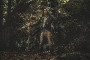 Shamanic man in ornamental dress in the nature.