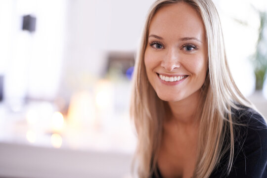 What a fetching smile. Portrait of a young blonde woman relaxing at home.