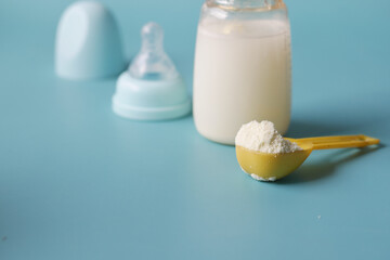 Fototapeta na wymiar Close up of baby milk powder and spoon on tile background.