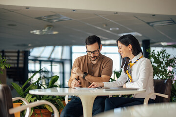 Nice caucasian woman with colorful scarf, helping her coworker w