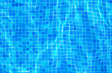 Fototapeta na wymiar Clear water surface, ripple water in tiled swimming pool with sun reflection