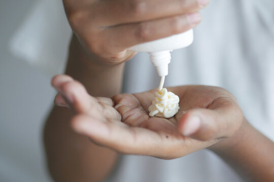 Men Using Sunscreen Cream And Pouring Cream On Hand 