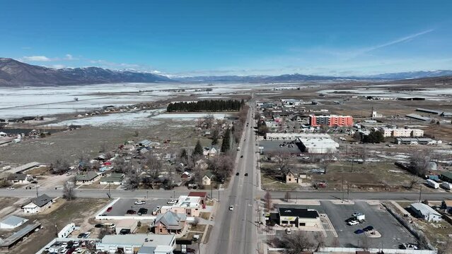 Aerial Rural town highway winter spring Utah. Aerial rural farming community agricultural economy. Home to Snow College campus. Mountain valley autumn agriculture field. Seasonal rural farm city.