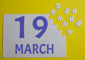 19 march calendar date on a white puzzle with separate details. Puzzle on a yellow background with a blue inscription
