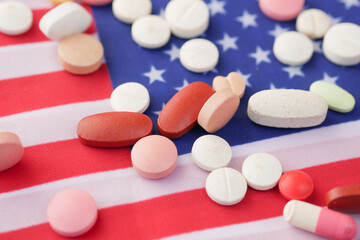 Obraz na płótnie Canvas white color medical pills spilling on american flag 
