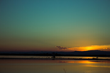 Obraz premium Dos personas a lo lejos contemplando el atardecer.