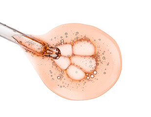 Liquid orange transparent gel or serum with dropper pipette on white isolated background
