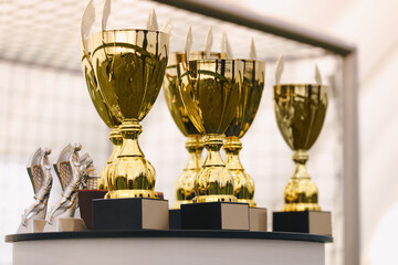 Photo of a set of golden trophies standing on the table. Golden cups for winners of sports...