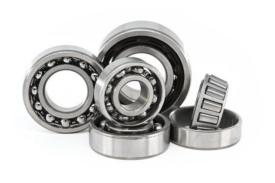 Group of various ball and roller bearings on white