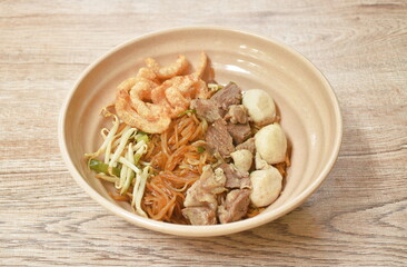 boiled dry thin rice noodles topping slice braised pork and meatball dressing sweet black soybean sauce on bowl