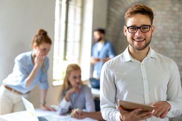 Portrait of happy successful business people working on tablet in office. Business teamwork concept