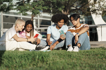Group of happy young diverse college university student friends looking at mobile cell phone in the...
