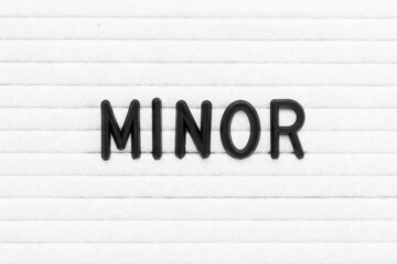 Black color letter in word minor on white felt board background