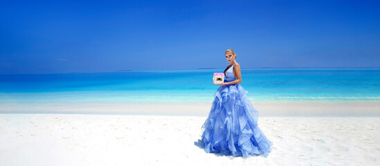 Summer fashion. Elegant fashion model. Glamour, stylish female model in elegant long gown dress on the Maldives beach. Travel model. Elegance. Bride on Maldives - concept. Bridal fashion.Classy woman.