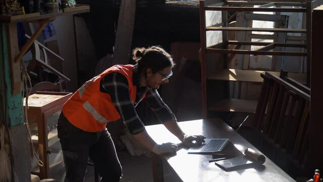 Happy and excited carpenter man celebrate to success with computer laptop with order and good news online . Business Owner wood worker In Workshop