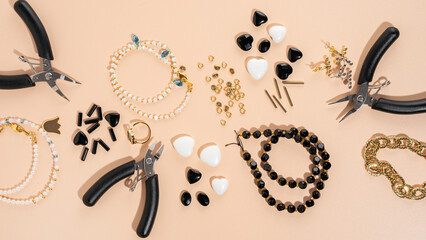 Tools and accessories for DIY jewelry in the workplace. Flat lay on beige background. Creative flat...