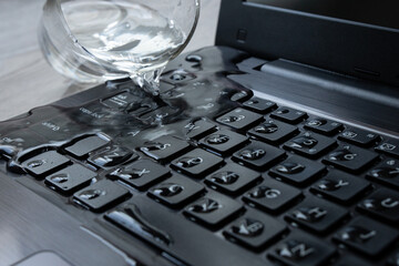 Water being spilled over laptop keyboard by accident. 