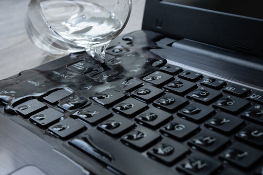 Water Being Spilled Over Laptop Keyboard By Accident. 