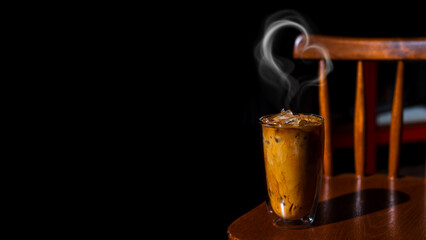 Ice coffee on a wooden table with cream being poured into it showing the texture and refreshing look of the drink