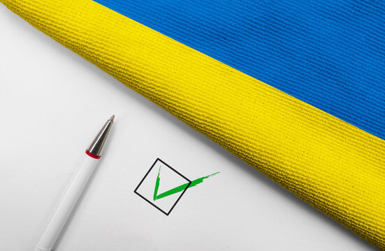 Pencil, Flag of Ukraine and check mark on paper sheet
