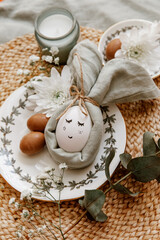 Fototapeta na wymiar Napkin folder idea. Easter table. Easter holiday table setting with egg in grey napkin Easter Bunny on a brown linen background. Copy space, top view, flat lay.