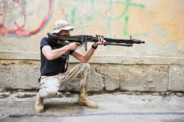 Fototapeta premium A man with an automatic weapon on the streets of the city