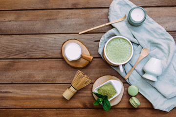 Japanese green matcha latte, matcha powder, bamboo whisk for whipping on old wooden board. Matcha tea healthy organic product rich of antioxidants. Top view.