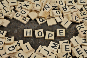 "hope" phrase surrounded by letters on a brown ceramic background