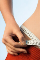 Frau misst mit Massband den H&uuml;ftumfang