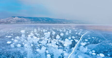 Naklejka na ściany i meble Baikal lake with transparent cracked blue ice at sunrise - Baikal, Siberia, Russia