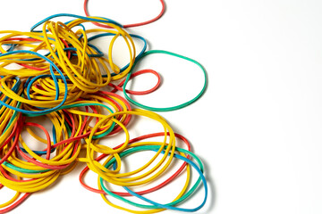 Colored rubber bands for money stacked in a pile on white background with copy space