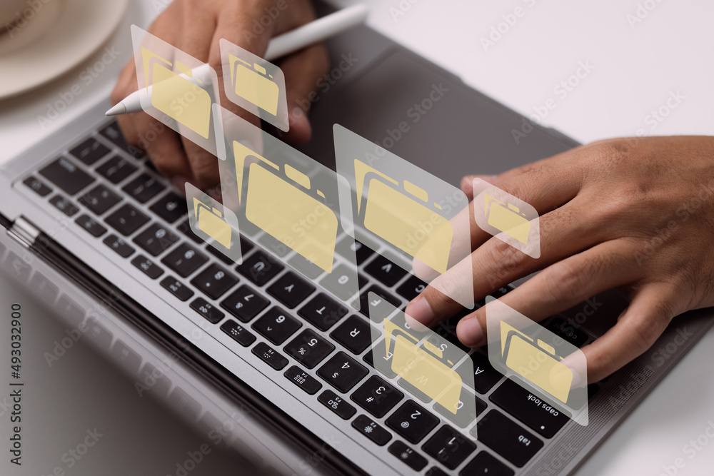 Poster Paperless workplace idea based on e-documents. On a virtual screen, a businessman works on a laptop computer keyboard with electronic document icons.