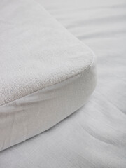 corner of the mattress with a mattress pad that does not let moisture through. White terry cotton...