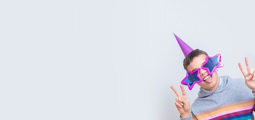 Banner with cheerful boy in funny glasses shows his tongue. April fool's day celebration concept with copy space