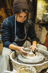 student in pottery workshop makes craft from clay