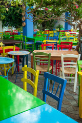 Fototapeta na wymiar Colourful Chairs in a Greek Restaurant 
