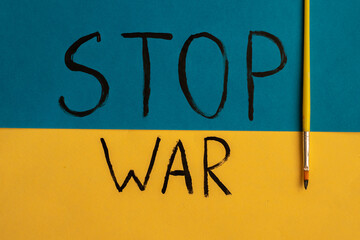 STOP WAR note on paper. A call to stop the war in Ukraine. Russia attacks Ukraine. Ukraine flag.