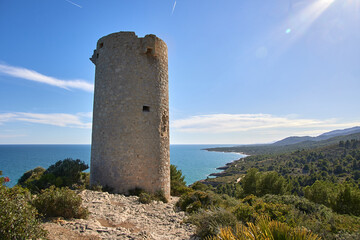 Torre Badum, para vigilancia en la edad media, con el Mar Mediterráneo detrás mostrando la línea de costa al fondo en el Parque Natural de la Sierra de Irta en Castellón