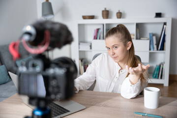 Influencer recording tutorial for social media platform. Young woman talking to camera