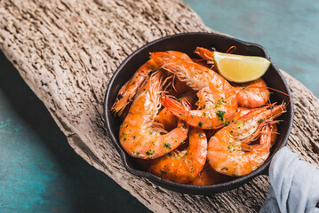 Shrimps in pan stir-fried tasty shrimps in pan on wooden background copy space.